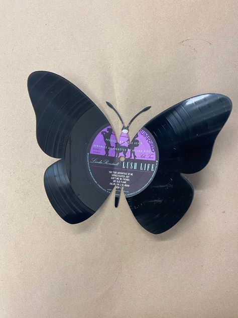 "the butterfly is laser cut and bent to give it that one of a kind look. It is 9 1/2\" wide when bent and almost 7\" tall Made from used records, the album is chosen at random. Our vinyl art is cut by with our laser, we can get pretty creative and detailed with the designs. All of our items are made local in the USA, by us Buffalo Customs. You guessed it right in Buffalo NY. We use a precision laser to cut or engrave our products. We do offer local pick up at our retail location, or we can ship Vinyl Record Butterflies, Cool Vinyl Designs, Crafts With Records Vinyls, Record Vinyl Art, Painted Vynal Records, Painted Vinyl Records Aesthetic, Record Art Ideas, Vinyl Painting Ideas, Unique Room Ideas