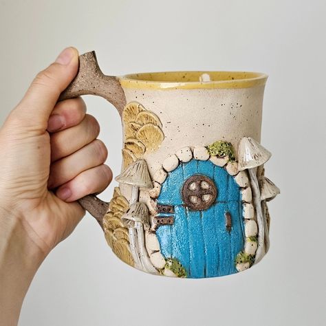 Fairy Door Mug, Hobbit House Mug, Handmade Stoneware Fantastic Mug, Mystical Gifts, One of a Kind Gift, Ceramic Beer Mug, Ceramic Mug #fairydoor #hobbithousemug #hobbithouse #handmadestonewareceramics #uniquegift #ceramicbeermug #ceramicmug #fairyhouse #cottagecore #cottagecoremug #fairymug #mushroommug #hobbitmug #handmadecoffeemug #fairyhousemug Mystical Gifts, House Mug, Hobbit House, Clay Mugs, Mug Handmade, Fairy Door, Stoneware Ceramics, Mug Ceramic, Class Ideas