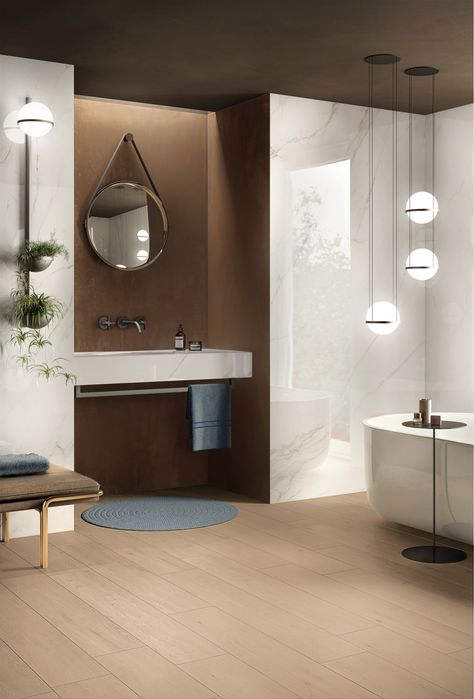 L’eleganza del marmo ceramico Calacatta Gold riveste il lavabo integrato a una vasca, della collezione Bath Design e contrasta con la grintosa matericità della nicchia posata con Interno 9 Rust, Il pavimento effetto legno Crossroad Wood Amber bilancia l’equilibrio cromatico dello spazio, in un perfetto Mix&Match firmato #abkemozioni. #ceramics #tiles #floortiles  #walltiles #gresporcellanato #porcelainstoneware #design #homedesign #homedecor #interiordesign #architecture #creative #madeinitaly Calacatta Gold Bathroom, Calacatta Bathroom, Bathroom With Tub, Bathroom Furnishings, Calacatta Gold, Gold Bathroom, Bathroom Wall Tile, Comfort Design, Dream Bathroom