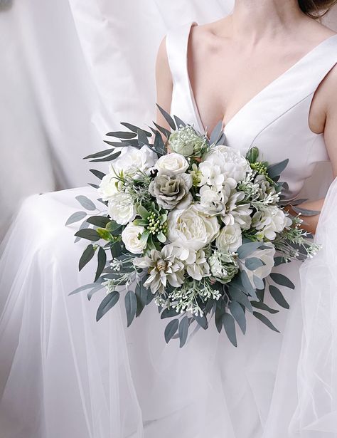 "White bridal wedding bouquet is created with high quality silk flowers. These handmade artificial wedding bouquets make beautiful additions to wedding and event floral arrangements. Flowers: peonies, roses, eucalyptus and fillers. Colors: white, green colors, sage, pale champagne. Handle: wrapped in ivory satin ribbon. Size: bridal bouquet is approximately 14\" wide, bridesmaids bouquet is 8\". SUGGESTION: steaming the bouquets upon receiving them and you will see how easily they will take the Bridal Bouquet Ivory, Champagne Flowers, Simple Wedding Bouquets, Green Wedding Bouquet, Artificial Wedding Bouquets, Green Bouquet, Wedding Bouquets Bride, Beautiful Wedding Flowers, White Bridal Bouquet