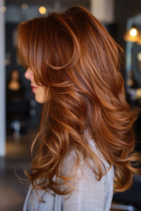 Woman with long, wavy auburn hair styled in layers. Ginger Tones Hair, Auburn Hait, Brownish Auburn Hair, Red Chestnut Hair Color, Auburn Hair With Curtain Bangs, Cinnamon Copper Hair Color, Auburn Hair Formula, Auburn Copper Hair Color, Blonde To Auburn Before And After