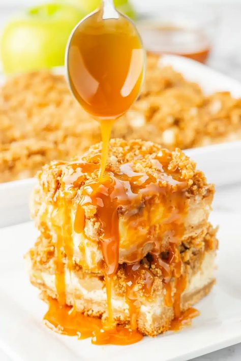 Starting with a brown sugar shortbread crust, these Caramel Apple Cheesecake Bars cradle an easy to make, velvety cheesecake layer. On top, a crunchy layer of apples is crowned with a buttery streusel topping and ribbons of caramel. It's the all-occasion fall dessert bar to make this season. This caramel apple dessert is also perfect for Thanksgiving dessert. Fall Dessert Bar, Apple Layer Cake, Smooth Cheesecake, Caramel Apple Cake Recipe, Brown Sugar Shortbread, Caramel Cheesecake Bars, Caramel Apple Desserts, Apple Cheesecake Bars, Caramel Apple Cheesecake Bars