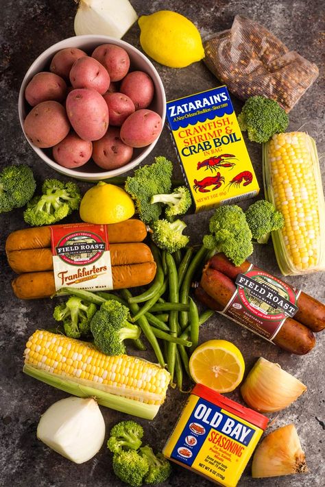 Ingredients for a vegan boil laid out on a surface - red potatoes, corn on the cob, broccoli florets, green beans, vegan sausage, and seasoning. Vegan Boil, Cajun Butter Sauce, Crab Boil Recipe, Vegan Cookout, Appetizers Seafood, Vegan Cajun, Vegan Crab, Cajun Butter, Seafood Boil Recipes