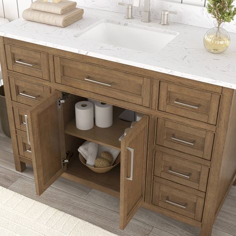 A classic transitional design and warm oak finish make the Connery 48-inch allen + roth vanity a perfect pick for your next bathroom remodel. A convenient tilt down drawer, 6 drawers (including 2 double drawers) and generous cabinet with adjustable interior shelf provide ample storage. The stunning Volkas white engineered top is pre-drilled for 8-in. widespread faucet and features matching backsplash and a pristine white rectangular undermount sink. The sleek brushed nickel hardware, soft-closing hinges, and solid wood frame testify to Connery’s quality. Pre-assembled for easy installation, Connery is available in multiple widths, including 24-in., 30-in., 36-in., 48-in., and 60-in. allen + roth Connery 48-in Warm Oak Undermount Single Sink Bathroom Vanity with White Engineered Stone Top i Weathered Tan Bathroom Vanity, Bathroom Vanity Craftsman, Wood Single Vanity Bathroom, Off Set Vanity Sink, Bathroom Vanity Single Sink 48”, White Washed Walnut Bathroom Vanity, Bathroom Vanity With, 5 Foot Bathroom Vanity Single Sink, Bathroom Ideas Single Vanity