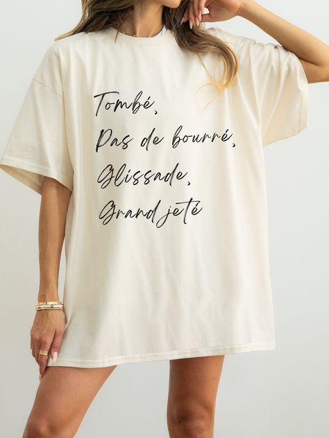 Elevate your style with our Tombé, pas de bourré, glissade, grand jeté t-shirt, a perfect fusion of grace and attitude. Crafted from soft, breathable fabric, this tee showcases a minimalist ballet-inspired design that effortlessly blends elegance with urban edge. Whether you're a dance enthusiast or just love the aesthetic, embrace the beauty of ballet in a whole new way. Available in various sizes, it's the ideal addition to your wardrobe for a touch of balletcore flair. D E T A I L S - Unisex Dancer Tshirt Ideas, Dance Tee Shirt Designs, Adult Ballet Class Outfit, Tshirt Slogans, Dancer Things, Ballet Outfits, Ballet Gifts, Ballet Inspired Fashion, Princess Ballerina