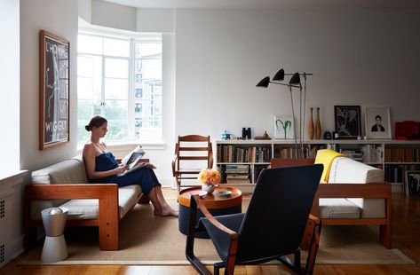 Living Room, Coffee Tables, Medium Hardwood Floor, Sofa, Carpet Floor, and Floor Lighting Luise Stauss, a former photo editor at The New York Times Magazine,  sits in the living room of the downtown Brooklyn apartment she shares with her husband, Nicholas Blechman, the creative director of The New Yorker. Downtown Brooklyn, Moving Blankets, Dwell Magazine, Tobia Scarpa, Brooklyn Apartment, Accent Wall Paint, Bay Windows, Times Magazine, New York Times Magazine