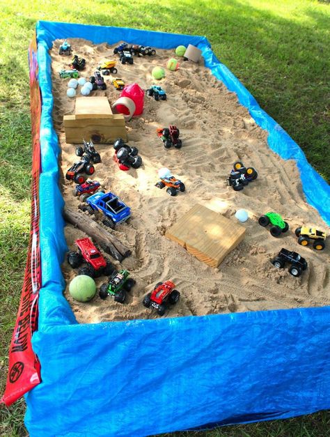 Monster truck sensory table. We took two pallets and nailed them together. Took the top slates out and set on top of 6 center blocks. Draped a tarp over the pallets and added sand! Wah la! Semi Truck Birthday Cake Ideas, Monster Truck Birthday Games Activities, Monster Truck Ideas, Monster Truck Photo Prop, Monster Truck Sand Pit Diy, Monster Truck Arena Ideas, 3rd Monster Truck Birthday, Monster Jam Goodie Bags Ideas, Monster Truck Play Area