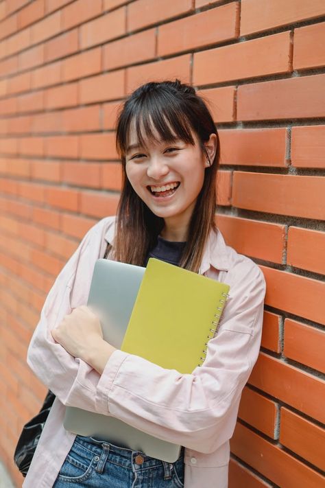 Joyful Asian female student leaning on university brick wall · Free Stock Photo Books To Read Before You Die, Paper Presentation, Academic Writing Services, High School Education, Bachelor's Degree, Admissions Essay, School Dropout, Research Proposal, Term Paper