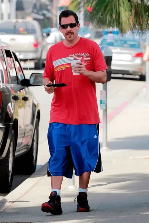 Adam Sandler always looks comfortable in basketball shorts and baggy tees (it’s his staple look), but he's been seen in other bizarre outfits over the years. Let’s see some of Adam Sander’s most iconic outfits. Adam Sandler Wife, Adam Sandler Outfits, Basketball Shorts Outfit, Dad Outfits, Spirit Week Outfits, Iconic Outfits, Adam Style, Outfits 90s, Outfit 90s