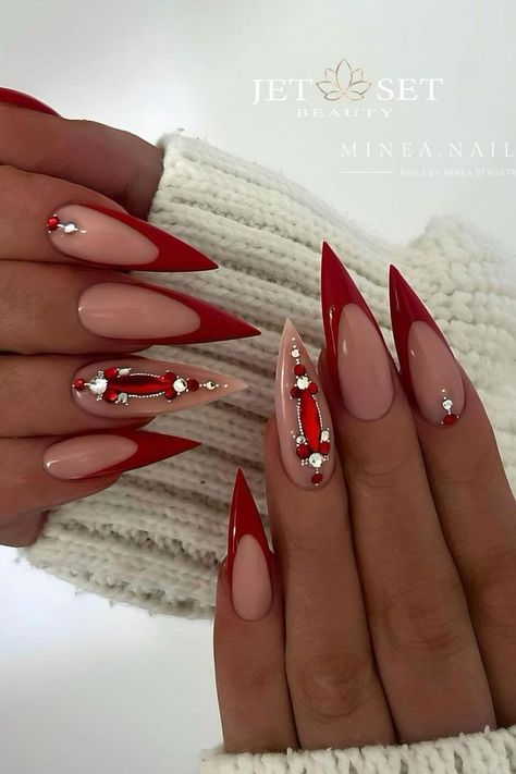 This bold stiletto manicure pairs striking glossy red with subtle nude shades. Featured nails display a captivating line work design embellished with tiny silver beads and red accents, creating an elegant contrast that's both edgy and chic. Perfect for adding a touch of glamour to any outfit.  // Photo Credit: Instagram @minea.nails Stiletto Christmas Nails, Cardi B Nails, Pink Stiletto Nails, Stiletto Shaped Nails, Red Stiletto Nails, Sophisticated Manicure, Christmas Nail Ideas, Long Stiletto Nails, Pointy Nails