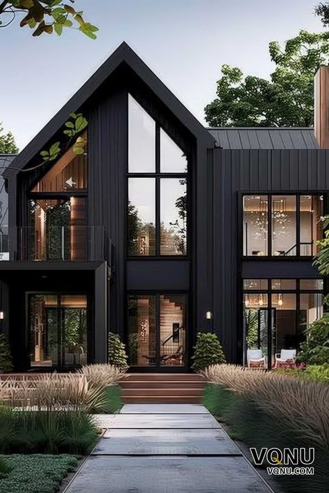 A modern black house with striking architectural design, large glass windows, and a beautifully landscaped entrance. Transitional Modern Home Exterior, Black And White Modern House, Very Modern House, Black Contemporary House, Black Lake House, Dark Modern House Exterior, Modern Container House Design, Transitional Exterior Home Design, Black Exterior House