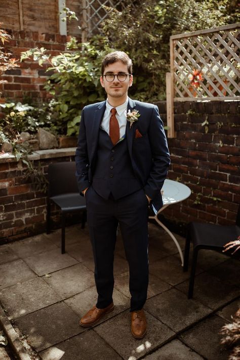 Groom in blue suit with brown handkerchief and tie with rounded glasses for church wedding Boho Wedding Groom, Hanging Plant Decor, Burnt Orange Bridesmaid, Groom And Groomsmen Outfits, Blue Groomsmen Suits, Rounded Glasses, Blue Groomsmen, Burnt Orange Bridesmaid Dresses, Groom Style Wedding