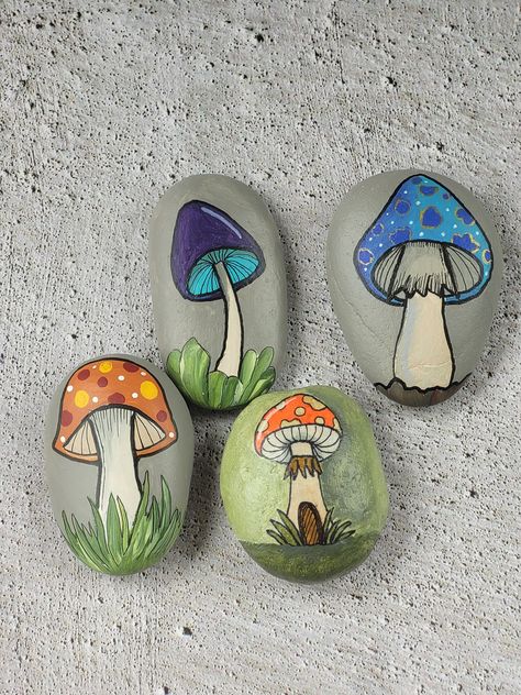 Enjoy these custom-made river rocks that have been hand drawn and painted by the artist. Each one is unique in color and nature.  Choose from 4 different stones to pick a special gift for the fungi collector or forager.  Super decor for a living room, garden room or garden shop. Each rock is drawn, and brush painted in a whimsical, colorful style. Sealed with a matte finish and signed on the back by the artist. Made in the USA. Painting Ideas Rocks, Painting Stones Ideas, Things To Make With Rocks, Fairy Garden Rock Painting Ideas, Scarecrow Painted Rocks, Painted Heart Shaped Rocks, Nature Painted Rocks, Painting On Rocks Ideas, Mushroom Painted Rocks