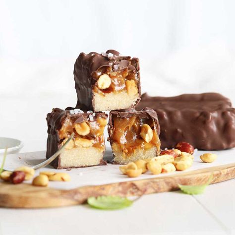 These extra special, easy, no-bake Keto Snickers Protein Bars have a secret ingredient in them: collagen peptides powder. It's what gives this recipe its distinct gooey, caramel-like centers, just like the classic candy bar. Paired with the low-carb coconut flour cookie base, the chocolate coating and the crunchy peanuts, you’ll never know that this bar contains 23g of protein per serving (more than 7 times of what’s contained in the original Snickers bar!) Collagen Peptides Recipes, Snickers Protein Bar, Keto Snickers, Snickers Protein, Sugar Free Pancake Syrup, Peanut Butter Easter Eggs, Greek Yogurt And Peanut Butter, Coconut Flour Cookies, Peanut Butter Protein Bars