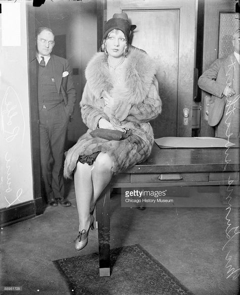 Full-length portrait of Louise Rolfe, girlfriend and sweetheart of Jack McGurn, looking to her right and sitting on a table in a room in Chicago, Illinois, wearing a fur coat, 1929. Two men are standing in the background. From the Chicago Daily News collection. Real Gangster, Chicago History Museum, Chicago Outfit, Mafia Gangster, Early Photos, Mae West, Pen Name, Al Capone, In Prison