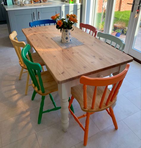 Colorful Painted Dining Chairs, Colored Chairs With Wood Table, Pop Of Color Kitchen Table, Different Color Chairs Dining Tables, Multi Coloured Dining Room Chairs, Colorful Kitchen Table And Chairs, Painted Pine Chairs, Upcycle Dinner Table, Painted Wooden Dining Chairs