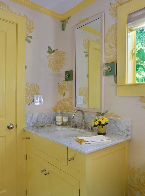 “For this project it was very natural to use yellow in the powder room [right off the kitchen],” she says. “I had no idea we’d be totally on-trend with Pantone’s color of the year—it just feels so organic.” The Hana Sisal wall covering is by Schumacher, and the Pop Sconces are from The Urban Electric Company. “I love their sconces…you can customize almost anything with them, so we chose a green backplate.” Yellow Bathroom Vanity, Bathroom Colors Schemes, Chesterfield Style Sofa, Patterned Fabrics, Yellow Bathroom, Window Treatments Living Room, Yellow Living Room, Yellow Bathrooms, Urban Oasis