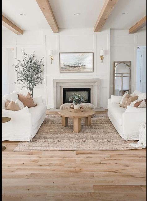 White Gold And Wood Living Room, White Wood And Gold Living Room, Cream And Light Wood Living Room, Poufs In Front Of Fireplace, White Walls Beige Carpet Living Room, White Fireplace Living Room Decor, White And Brass Living Room, Neutral Living Room Gold Accents, Sofa And Armchair Living Rooms