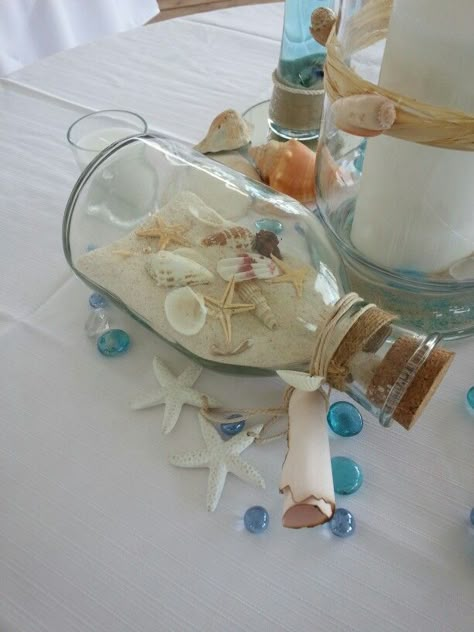 Beach wedding on a dime! Goodwill bottle with collected shells Beach Theme Wedding Reception Tables Centerpiece Ideas, Classy Beach Theme Party, Seashell Themed Party, Beach Themed Table Centerpieces, Ocean Themed Centerpieces, Ocean Centerpieces, Beach Centerpieces Diy, Beach Wedding Table Centerpieces, Beach Theme Centerpieces