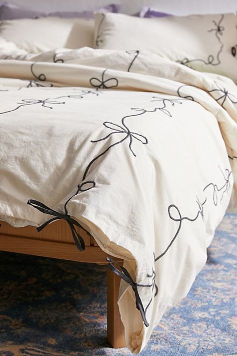 Our fave femme icon gets a chic refresh with this lightweight cotton embroidered duvet cover. Its crisp construction features textural bows stitched allover the top panel with a solid cotton panel at the reverse for a silky-soft finish. Pair it with our Lacey Bows Sham Set for a coordinated bedding set. Available exclusively at Urban Outfitters. Features Chic bow duvet cover from UO Home in crisp cotton Finished with textural bows allover the top panel Backed with a solid cotton panel Hidden but Bow Bedding Urban Outfitters, Single Bed Duvet Set, Duvet Wallpaper Iphone, Adding Clour To White Bed Cover, Cute Bed Covers White, Bed Covers Queen, Danish Pastel Bed Set, Bed Covers For Single Beds, Cute Bedroom Bedding