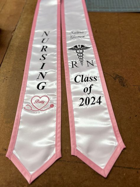 NURSING- RN Graduation Stole Stole is made just like picture. Your name will be added And your class year can be changed.  Right side: -Nursing with stethoscope heart with name inside (optional) Left side: -Your Name (script) -Class of 202X -Med symbol & RN or your Major   Use Pictures for reference, Will be just like picture. -Your Choice of Stole color -Your choice of edge color  -Your choice of thread color  Any additions will be an extra charge. -Message me for any particular color or any qu Nursing Graduation Stole, Nursing School Cap Decoration, Future Nurse Graduation Cap, Nursing School Graduation Cap, Nurse Pinning, Graduation Designs, Nursing School Supplies, Grad Stoles, Pinning Ceremony Nurse