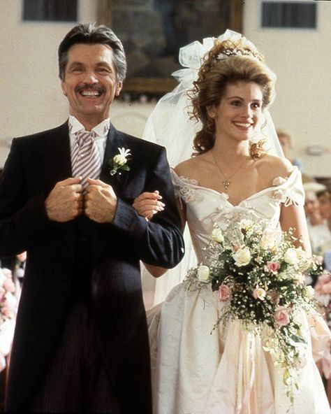 The first of many roles for which Julia Roberts would wear a wedding dress, Southern belle Shelby chose a feminine pale pink ball gown by Julie Weiss in the 1989 drama. With pink flowers on the bodice and pink sashes in the skirt, the bridal look was befitting for a girl whose wedding colors were "blush and bashful," or "pink and pink." Southern Wedding Dresses, Movie Wedding Dresses, Bride Wars, Wedding Dress Costume, Tv Weddings, Kimberly Williams, Magnolia Wedding, Runaway Bride, Celebrity Wedding Dresses