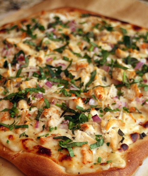 The pizza is topped with a garlic and cheese bechamel sauce, then is topped with fresh herbs after its done baking.