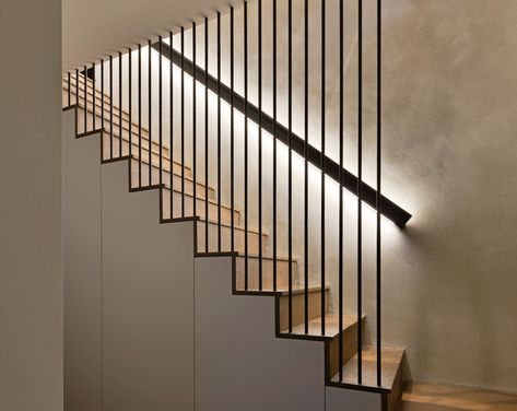 These modern wood stairs have a handrail with hidden lighting, and a floor-to-ceiling steel rod safety barrier. #WoodStairs #Handrail #BacklitHandrail Wood Stair Handrail, Stairs Handle, Handrail Lighting, Stairwell Lighting, Hidden Lighting, Handrail Design, Stair Railing Design, Stairs Design Modern, Stair Case