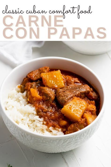 A white bowl of cuban beef stew on white rice with the words "classic cuban comfort food Carne con Papas" in the foreground