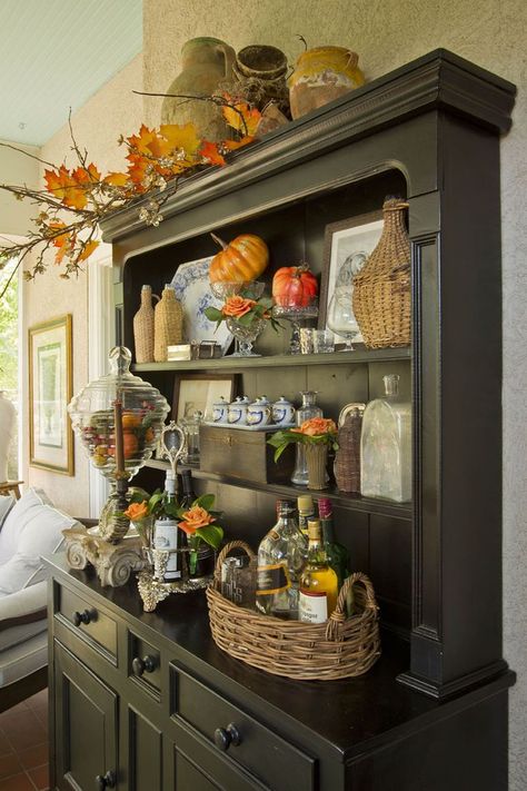 For this fall decor, entrepreneur and store owner Mary Carol filled a tall apothecary jar with faux pumpkins and tucked artificial tree twigs into an existing display. Old China Cabinet, Black Hutch, House Redo, Hutch Decor, China Hutch, Dining Room Hutch, Fall Kitchen Decor, Autumn Ideas, Autumn Decorating