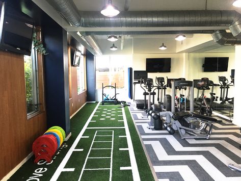 Making use of space in this apartment complex gym for agility and movement based functional fitness. Custom artificial turf area with design agility ladder, agility dots, hash marks, and lanes for sprints and Sled pushes. MoveStrong can design functional surfacing needs to fit any gym space along with customized fitness equipment that looks unique and upscale for apartment gyms. Garage Gym With Turf, Turf Home Gym, Home Gym With Turf, Home Gym Turf, Apartment Gym, Home Gym Inspiration, Small Gym, Dream Home Gym, Dream Gym