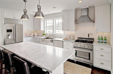 Amazing kitchen features white shaker cabinets paired with white marble countertops and a white mini brick tiled backsplash. Unusual Kitchen Layout, Kitchen Wall Oven, Stainless Steel Apron Sink, Brick Tile Backsplash, Wall Oven Kitchen, Replacing Kitchen Countertops, Kitchen Cabinet Layout, Crown Moldings, White Shaker Cabinets