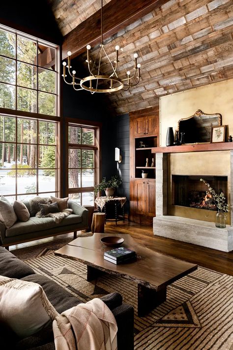 Soaring, barn-wood–clad ceilings and massive windows meet dark, moody colors for a cocoon-like feel in this Lake Tahoe cabin. Hunting Cabin Interior Living Room, Dark Moody Cabin Interior, Dark California Cool Interior, Wooden Cabin Interior Design, Relaxed Elegance Interior Design, Moody Mountain Living Room, Dark Cozy Cabin Interior, Moody Log Cabin, Moody Mountain Aesthetic Home