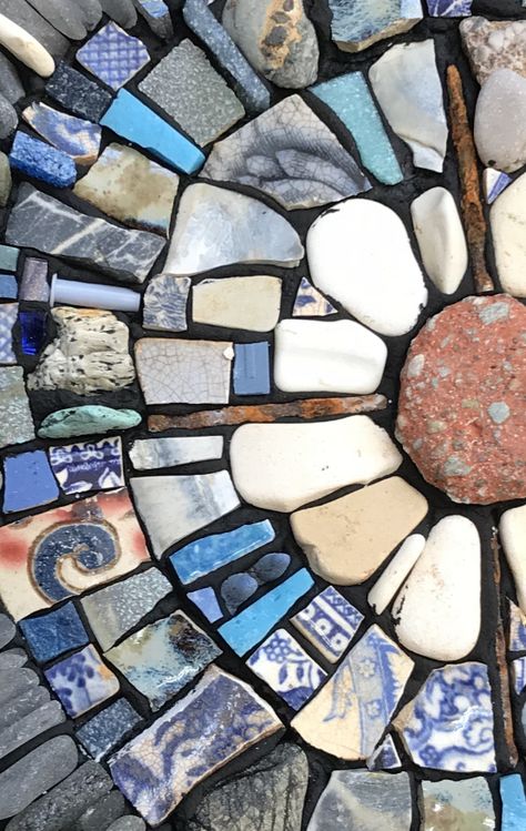 Detail of a mosaic made with found and recycled materials Mosaic Recycled Materials, Mosaic Art On Rocks, Sea Glass Mosaic Diy, Mosaic Ideas Beginner Tile, Recycled Glass Mosaic, Mosaic Rocks Design, Beach Pottery Art, Sea Pottery Mosaic, Rock Mosaic Art