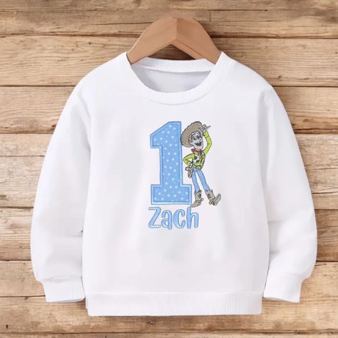 🌟 Yeehaw! Celebrate your little one’s first birthday in style with this adorable *Toy Story* sweatshirt featuring everyone’s favorite cowboy, Woody! 🤠 Perfectly personalised with their name, this cosy top is a keepsake they’ll cherish forever. 💙 Whether it’s for birthday photos, parties, or just a fun day out, this sweatshirt will make your little sheriff the star of the show! 🌟 🎈 Shop now for a unique birthday look that’s as special as they are! 🎂 #ToyStory #Woody #FirstBirthday #Personal... Toy Story 1st Birthday, Woody From Toy Story, Cowboy Outfit, Outfit For Boys, Birthday Look, Birthday Sweatshirt, Baby Jumper, Toy Story Birthday Party, Baby Boy Clothing Sets