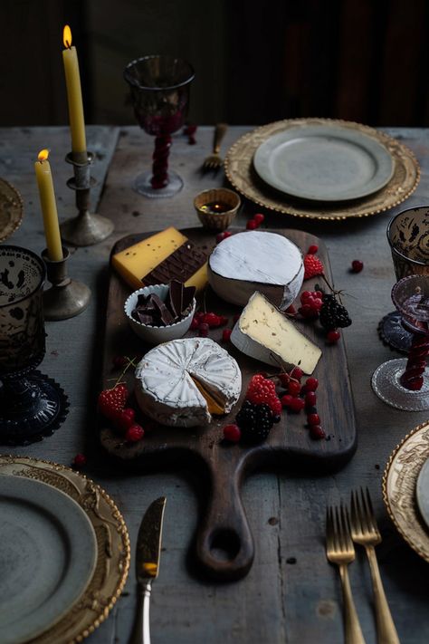 A vintage wooden cheese board with a dark finish, featuring brie, gouda, dark chocolate, and berries, surrounded by antique glassware and soft candlelight for a gothic dinner setting. Gothic Dinner, Board Inspiration, Aesthetic Vintage, Charcuterie Board, Dining Experiences, Dark Aesthetic, The Vintage, Cheese Board, Cheese