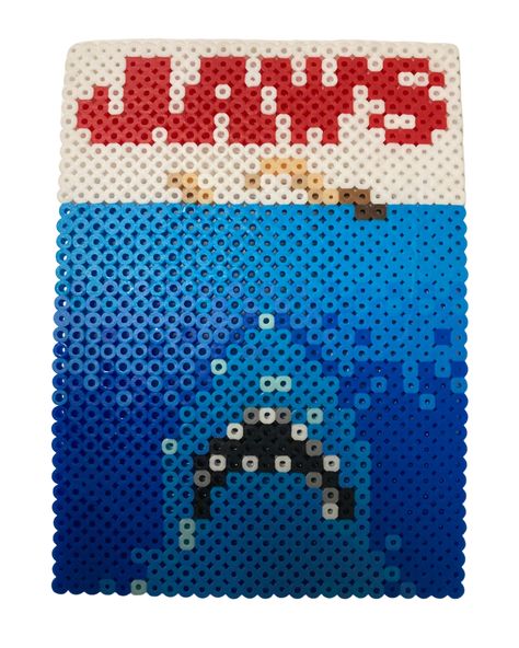 Perler bead pattern inspired by the iconic Jaws movie poster. This fun, awe-inspiring craft project not only enhances your artistic skills but also helps in expressing your love for classic cinema. Follow this interactive guide and unleash your imaginative side. Happy Beading! Jaws Pixel Art, Perler Bead Movie Poster, Fish Perler Beads, Movie Perler Beads, Jaws Movie Poster, Melt Beads, Melt Beads Patterns, Hamma Beads Ideas, Jaws Movie