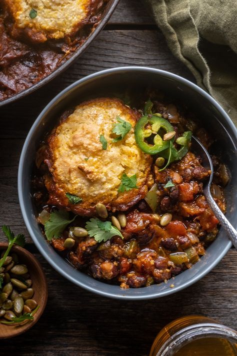 This hearty Black Bean Chili with Cornbread Biscuits is the perfect vegetarian comfort food! All made in one pot, with canned black beans, fire roasted tomatoes, smoky chipotles and a fluffy cornmeal biscuit topping. Delicious and easily adaptable for vegan! Chili With Cornbread Topping, Chili With Cornbread, Cornbread Topping, Cornbread Biscuits, With Cornbread, Chili Toppings, Vegetarian Comfort Food, Black Bean Chili, Bean Chili