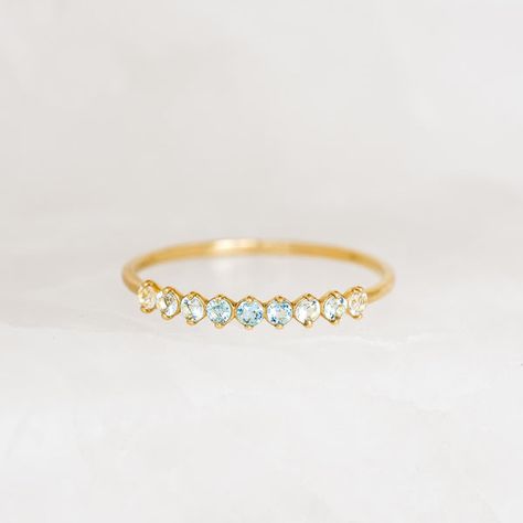 Inspired by the mystical allure of birthstones, this delicate 14k gold ring features an ombre gemstone arrangement of aquamarine and blue and white topaz. The mesmerizing transition of hues makes it a perfect and meaningful gift for yourself or a loved one born in March. Blue topaz (March birthstone) is the stone of emotional clarity Aquamarine is the stone of serenity and harmony White topaz is the stone of truth and clarity 3 blue topaz stones, each with a width of 1.75mm 4 aquamarine ... Aquamarine Birthstone Ring, Born In March, March Birthstone Ring, Topaz Color, Blue Topaz Stone, March Birthstone, Ring Ideas, Detailed Ring, Aquamarine Stone