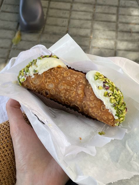 Hand holding an Italian cannoli dessert with pistachio crust Italian Food In Italy, Cannoli Aesthetic, Cannoli Pistachio, Pistachio Cannoli, Dessert Cannoli, Italian Aperitivo, Italian Street Food, Italian Bakery, Italian Pastries