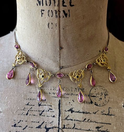 Featuring an amazing antique Victorian Aesthetic Movement Era gold plated bib necklace adorned with beautiful intricate gold rolled connectors accented with brilliant faceted Amethyst Purple bezel set Paste stones accented with dainty paste stone accents .  This delicate feminine antique necklace is in excellent antique condition with minimal patina, a functional marked antique thumbless clasp with all stones intact and accounted for.  Necklace measures approximately 15 inches around with a 1 1/ Aesthetic 1800s, Victorian Jewelry Necklace, 1800s Jewelry, Spring Court, Victorian Aesthetic, Stone Choker, Aesthetic Movement, Bib Necklaces, Antique Necklace