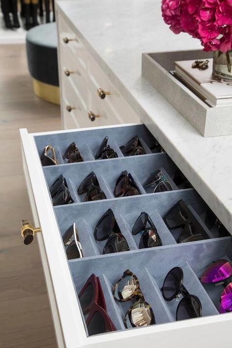 A white closet island drawer accented with a gray glass and brass knob opens to reveal a blue velvet sunglass organizer fitted beneath a marble countertop. Storage Tricks, Chic Closet, Closet Island, Sunglasses Organizer, White Closet, Dream Closet Design, Drawer Inserts, Closet Decor, Organize Drawers