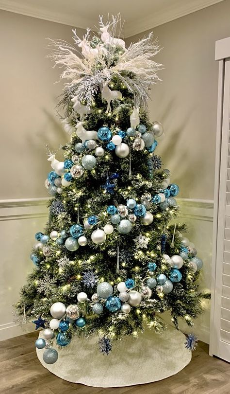 a chic Christmas tree with blue, silver and white ornaments, snowflakes, lights and white branches and deer on top Blue And Silver Christmas Tree Ideas, Crismas Tree, Turquoise Christmas Tree, Blue Christmas Tree Decorations, Elegant Christmas Tree Decorations, Christmas Tree Inspo, Ideas Christmas Tree, Gold Christmas Tree Decorations, Pretty Christmas Decorations