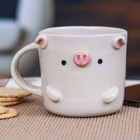 Meet your new favorite coffee companion: an adorable piglet-shaped ceramic mug from Thai artisan Paiboon. Its hand-painted charm and smooth, glossy finish transform every beverage into a cheerful experience. Mug Pinch Pot, Pig Mug Pottery, Ceramics Ideas Pottery Animals, Animal Ceramic Mug, Animal Ceramic Mugs, Mug Ideas Pottery, Sculpted Mugs, Pottery Mug Ideas, Cow Pottery