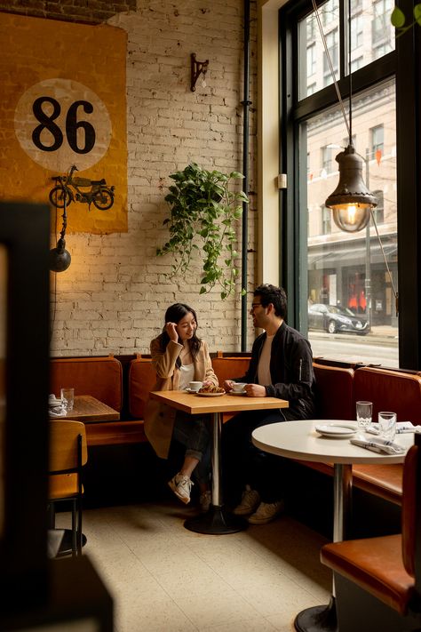 couple sitting in gastown coffee shop during engagement session Couple Poses Coffee Shop, Couple At Coffee Shop Aesthetic, Pre Wedding Shoot Ideas In Cafe, Engagement Pictures Coffee Shop, Couples Cafe Photo, Coffee Shop Proposal, Coffee House Engagement Photos, Coffee Shop Engagement Shoot Photo Ideas, Coffee Shop Date Photoshoot