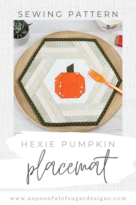 Photos shows a hexagonal placemat sitting on a wooden base. It consists of a bright, orange, foundation paper pieced pumpkin in the centre with a simple patchwork border in shades of grey/beige. Finised with a khaki coloured binding. In the background is a small plant, cup, and biscuit. Orange Prints, Halloween Placemats, Quilt Cards, A Spoonful Of Sugar, Cat Coasters, Pattern Store, Foundation Paper Piecing, Autumn Halloween, Modern Farmhouse Style