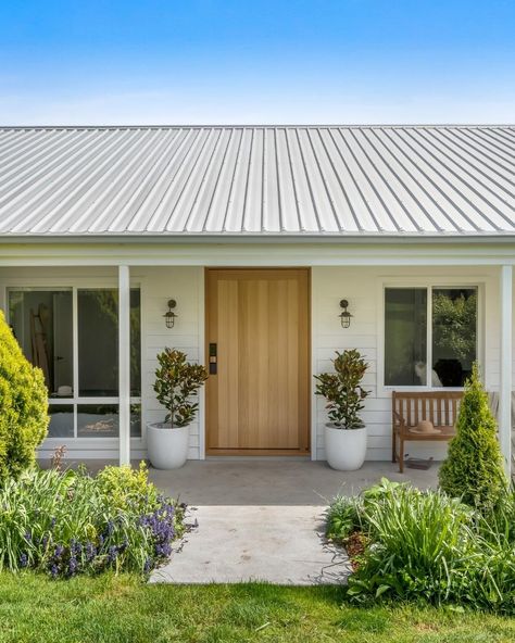 This country home may inspire a tree change 🌳. Owners Lydia and Martin had strong ideas for its renovation – one of which was covering the dated peach and tan brick exterior of their 1990s house to create something with a more modern country feel.  This is where Linea™ Weatherboard came in. 🔗 More about the story behind this cladding over brick project at the link. Brick Farmhouse Exterior, House Exterior Before And After, Weatherboard House, Brick Projects, Modern Coastal Home, Australia House, Home Transformation, Brick Exterior House, Brick Home