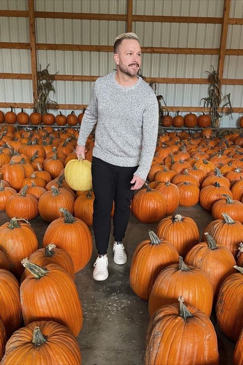 man surrounded by hundreds of orange pumpkins carrying a yellow pumpkin while wearing a sweater, black joggers and white sneakers Mens Pumpkin Patch Outfit, Best Outfits For Men, Fall Family Outfits, Patch Outfit, Pumpkin Patch Outfit, Casual Basics, Outfits For Men, The Best Outfits, Fall Staples