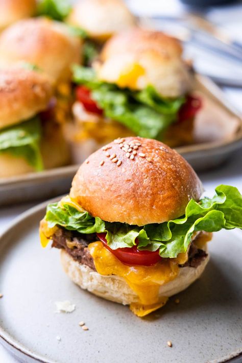 Mini cheeseburger slider on a plate with melted cheese dripping down from the side. Mini Beef Sliders, Christmas Eve Finger Food Ideas, Mini Hamburger Sliders, Mini Burgers Sliders, Christmas Eve Dinner Ideas, Homemade Sliders, Hamburger Sliders, Mini Cheeseburger, Homemade Cheeseburgers