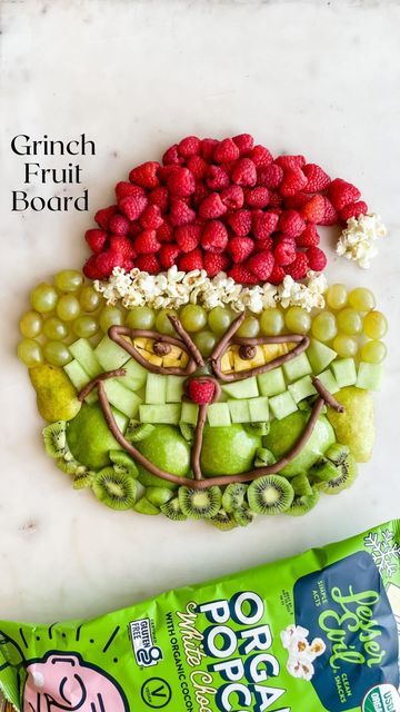 Steph | Healthy Family Recipes & Food Hacks on Instagram: "This Grinch Fruit Board is so fun for a Christmas party! It’s the perfect healthy snack for all of your little Whos! ⭐️ Follow for more simple, healthy holiday recipes ⭐️ I saw @playpartyplan share a Grinch candy board, and I knew I wanted to make one with fruit in collaboration with @lesserevilsnacks. All you need are a bunch of green fruits, red fruit, yellow fruit, chocolate icing, and popcorn. We love @lesserevilsnacks White Chocol Healthy Christmas Fruit Tray, Grinch Fruit Platter, Grinch Party Food Ideas, Grinch Fruit Tray, Holiday Fruit Tray, Christmas Fruit Tray Ideas, Grinch Charcuterie Board, Christmas Fruit Snacks, Christmas Fruit Tray